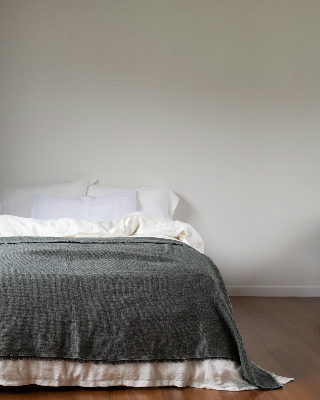 Primary bedroom with neutral bedding and soft morning light