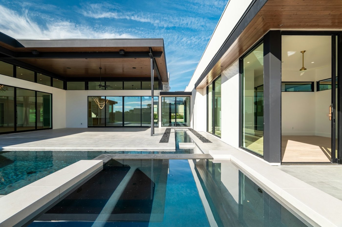 Modern courtyard with reflecting pool connecting two glass pavilions