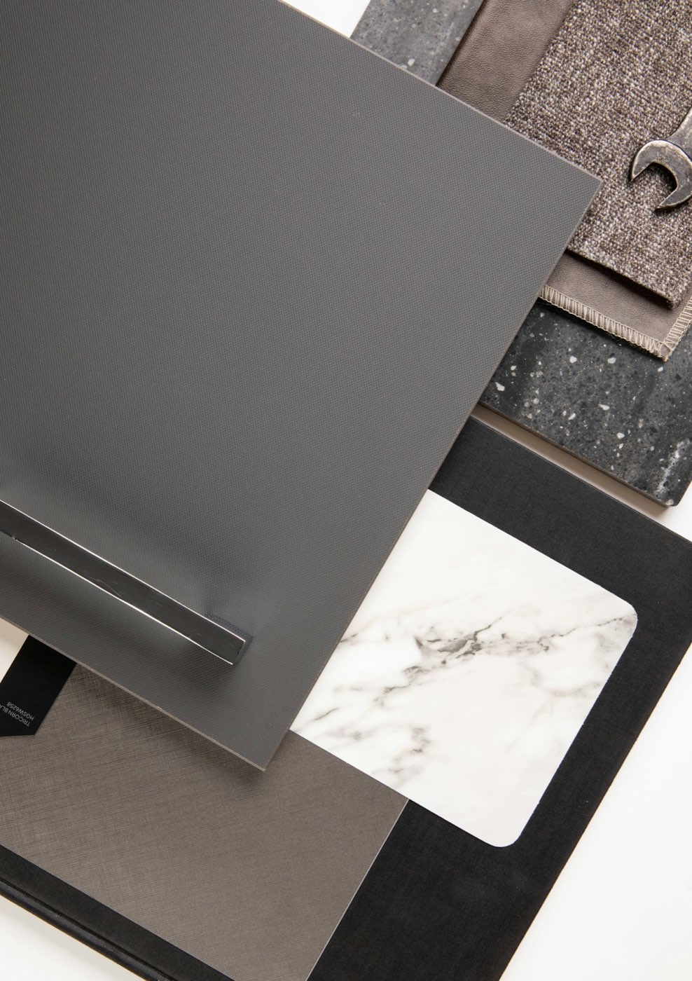 Neutral material samples arranged on a white studio surface